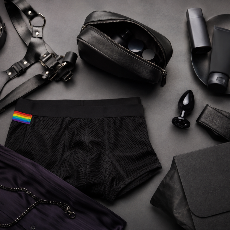 Clonezone Direct LGBTQ+ lifestyle and adult wellness flat lay featuring underwear, fashion accessories, discreet packaging and pride-inspired styling.