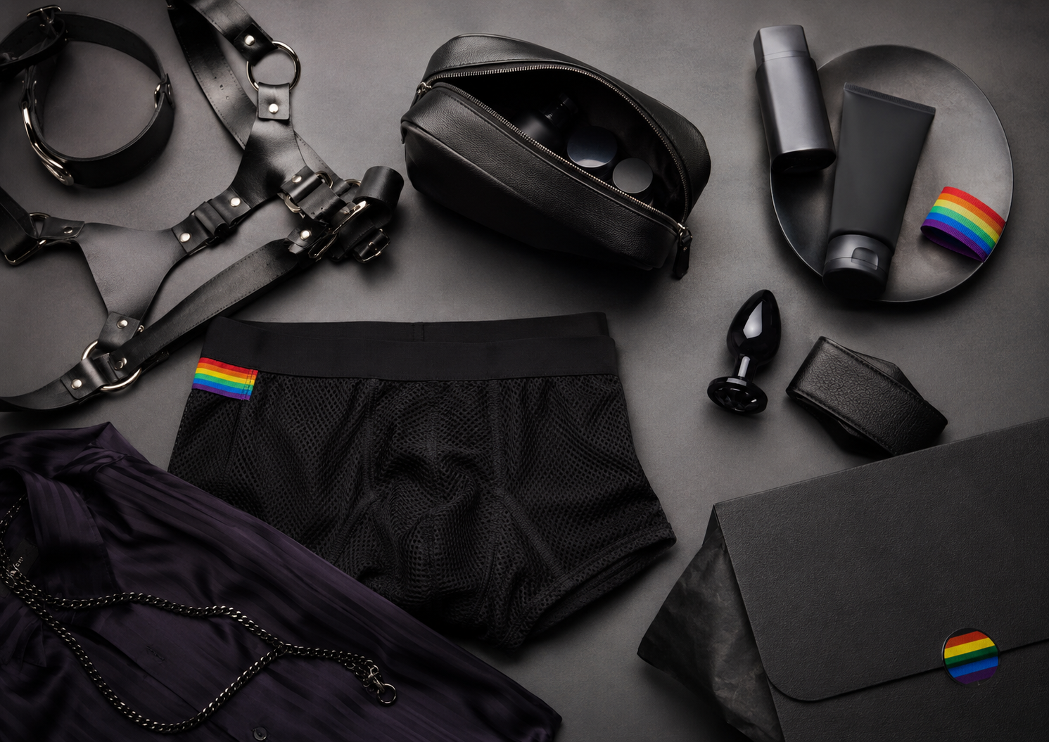 Clonezone Direct LGBTQ+ lifestyle and adult wellness flat lay featuring underwear, fashion accessories, discreet packaging and pride-inspired styling.